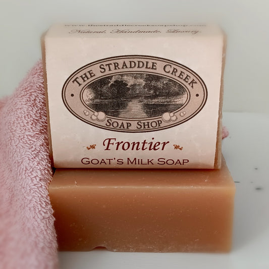 Bar of Frontier goat's milk soap from The Straddle Creek Soap Shop on a pink towel.