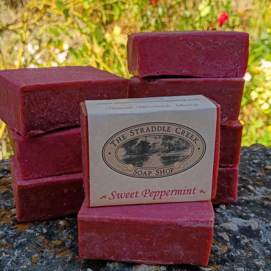 Stack of red soap bars with a Straddle Creek Soap Shop label on a natural background