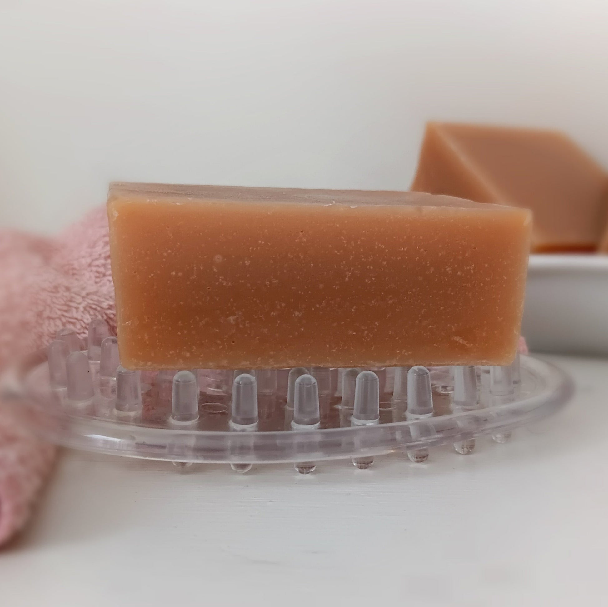 Bar of goat's milk soap on a clear soap dish